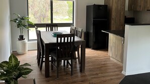 Eine moderne Küche mit Essbereich, Holzboden und einem großen Fenster.