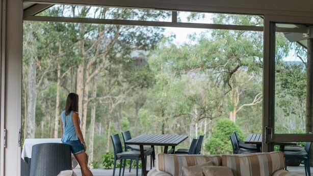 A covered outdoor area with a sofa, chairs, and a table. - Elfin Hill Country Accommodation (Pokolbin)