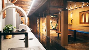 A cozy indoor space with a counter, seating area, and a hammock. - Bali at the Bay (Nelson Bay)