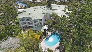 A multi-story building with a swimming pool surrounded by trees. - The Lookout Resort (Noosa Heads)