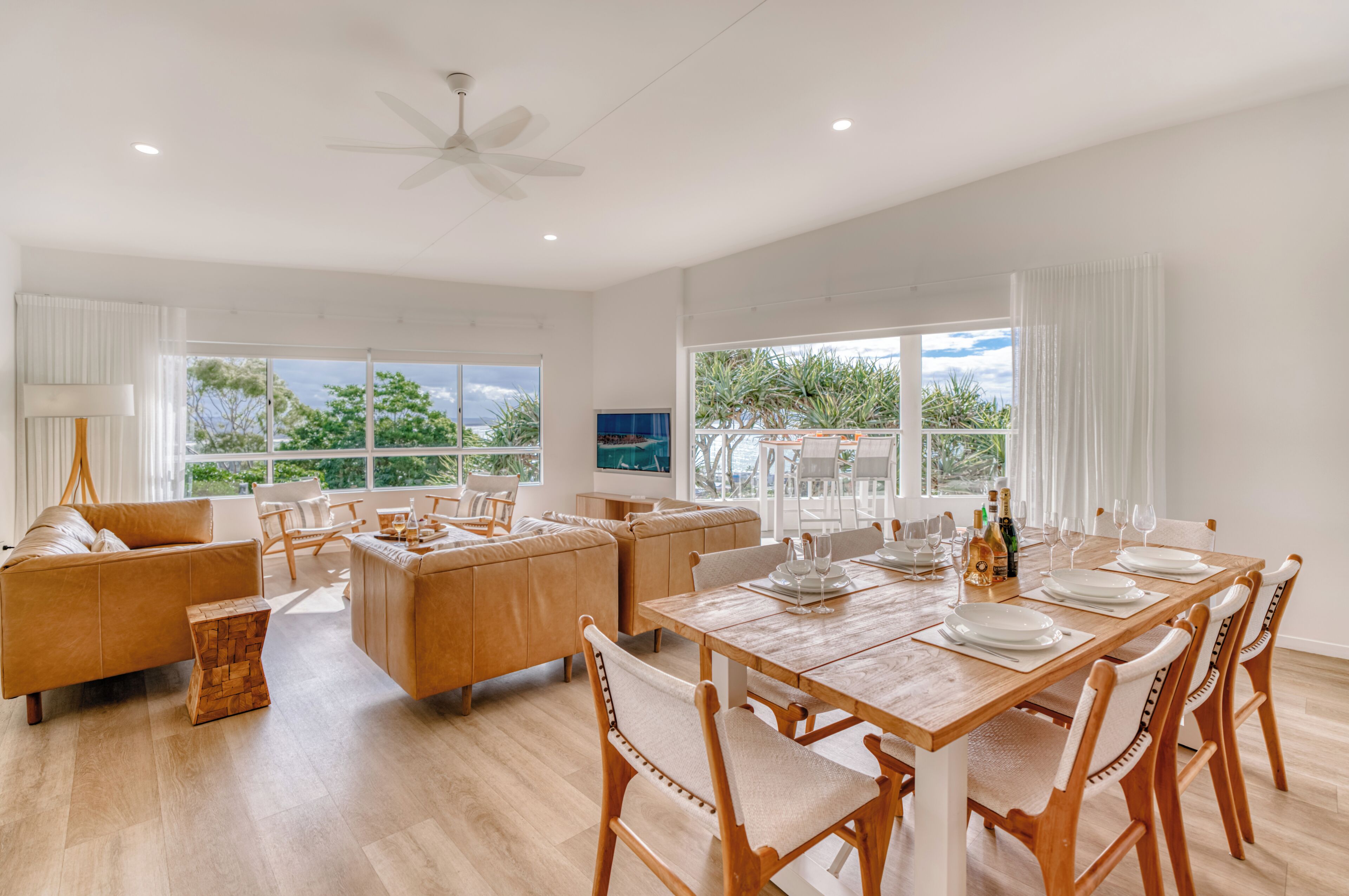 A spacious living area with a dining table set for six, surrounded by comfortable seating.