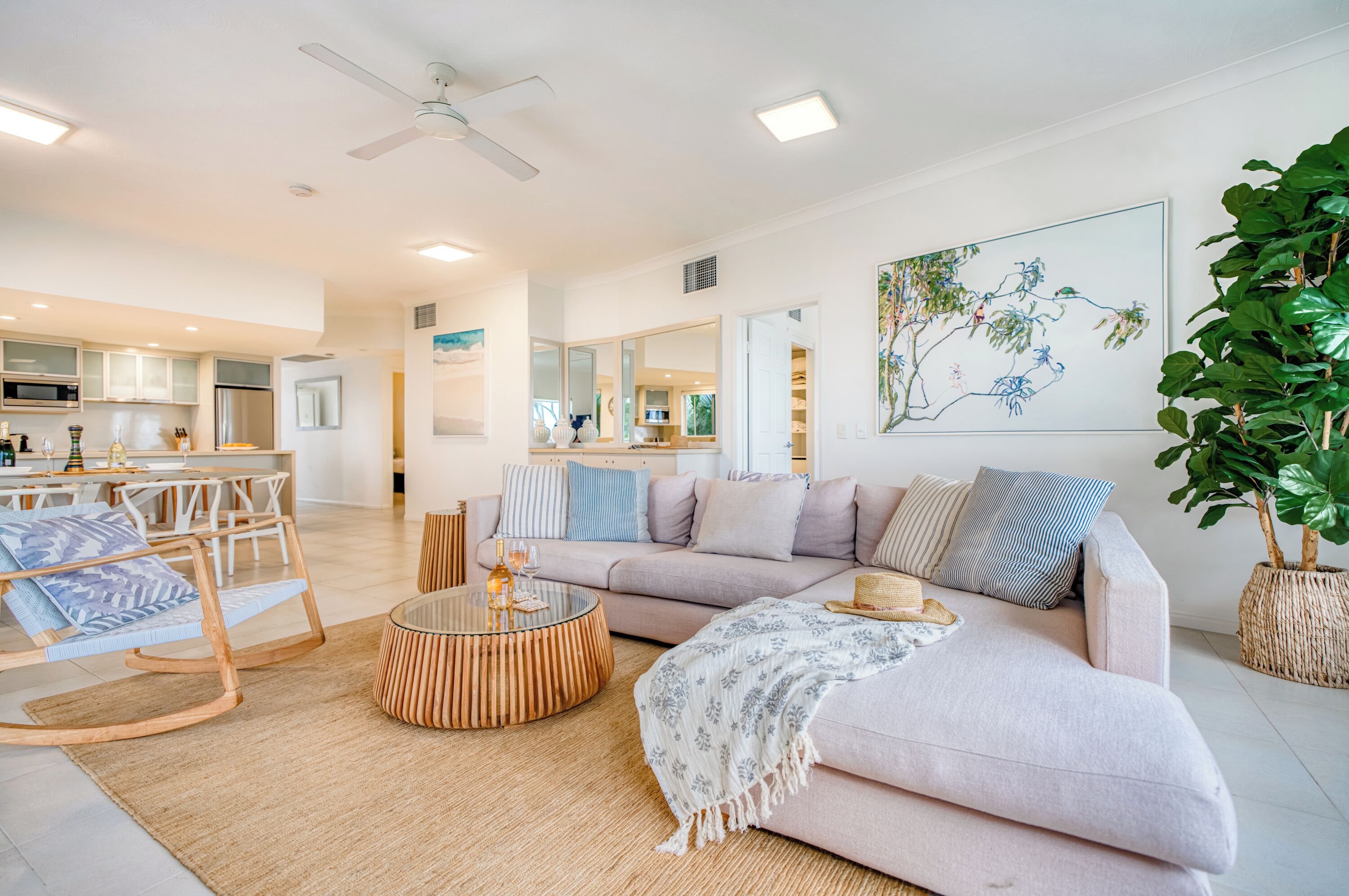 A modern living room with a sofa, a coffee table, and a dining area.