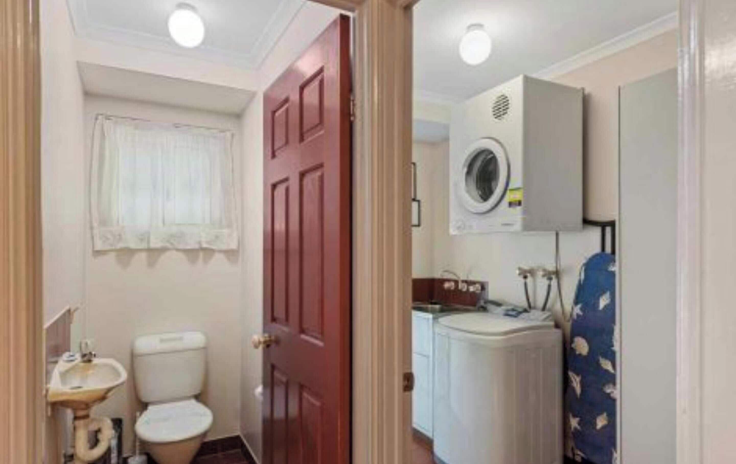 Ein kleines Badezimmer mit Toilette, Waschbecken und Waschmaschine.
