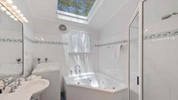 Een moderne badkamer met dakraam, een vrijstaand bad en een inloopdouche.