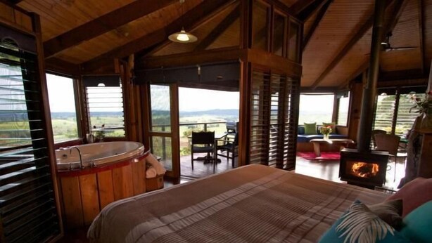 Un dormitorio con una cama grande, un jacuzzi y una chimenea.