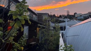A residential area with modern houses, a narrow alley, and a view of the sunset over the neighborhood. - On Top Apartments & Hostel Backpackers (Dunedin)