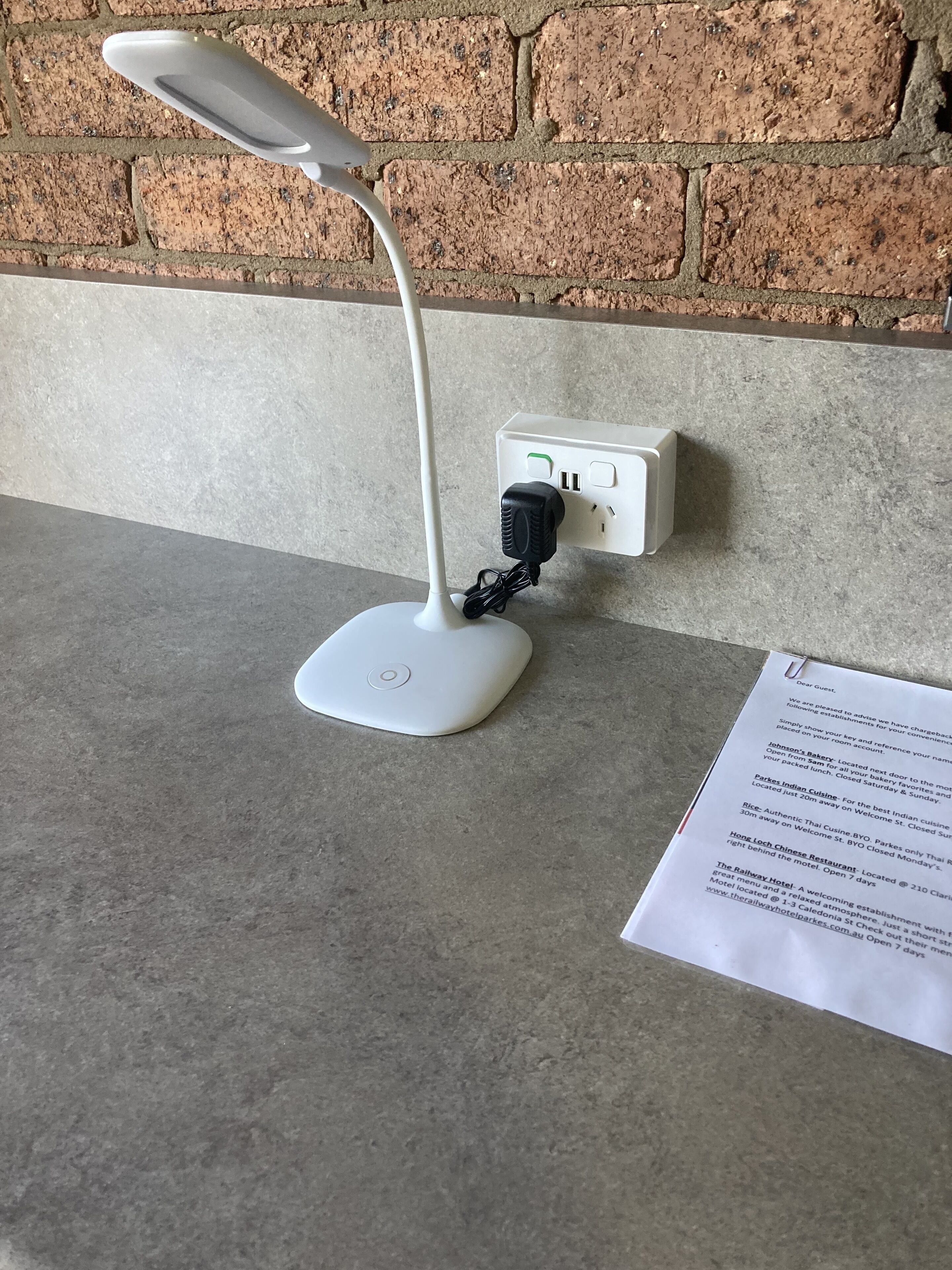 Una lámpara de escritorio con un cable USB conectado a un enchufe de pared.