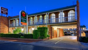 Un edificio de ladrillo con un letrero que indica Motor Inn Henry Parkes y Motor Inn Hamilton.