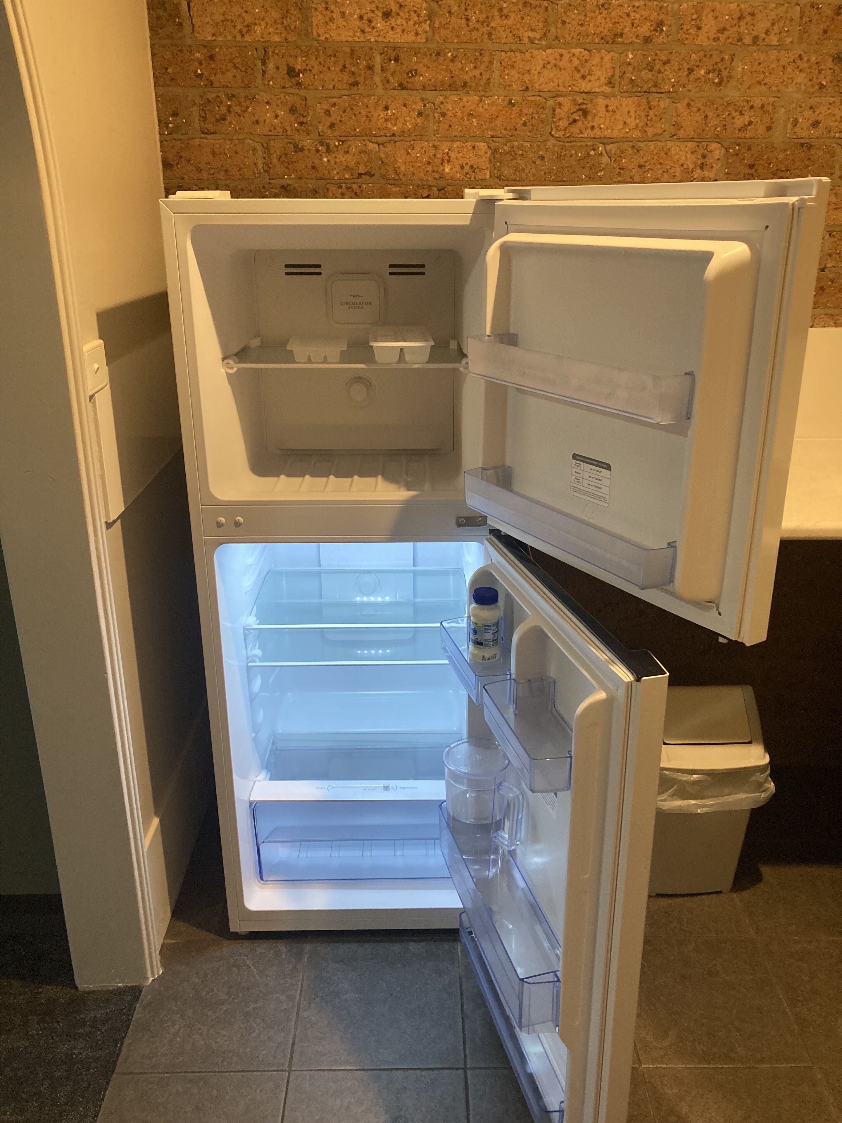 An open refrigerator with multiple shelves and a freezer compartment.