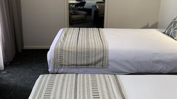 Una habitación de hotel con cama, una silla, un escritorio y televisión.