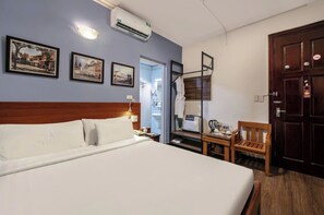 A hotel room with a large bed, a desk with a chair, a wardrobe, and two framed pictures on the wall. - A25 Hotel - Doi Can 2 (Hanoi)