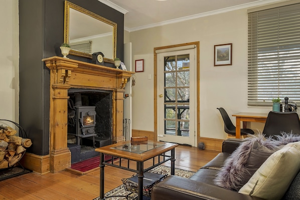 A cozy living room with a fireplace, a dining table, and a comfortable sofa.