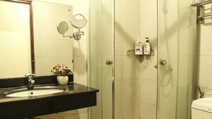 A bathroom with a black sink, a mirror, and a shower area.
