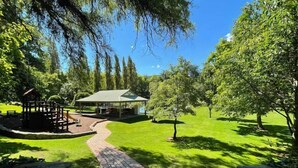 Un parque con un pabellón, una zona de picnic y un sendero pavimentado.