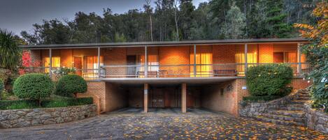 Un edificio in mattoni di due piani con un ingresso coperto e un balcone.