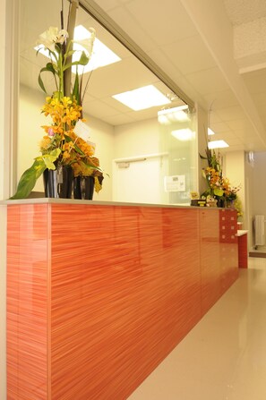 Una recepción con detalles en rojo y varios arreglos florales.