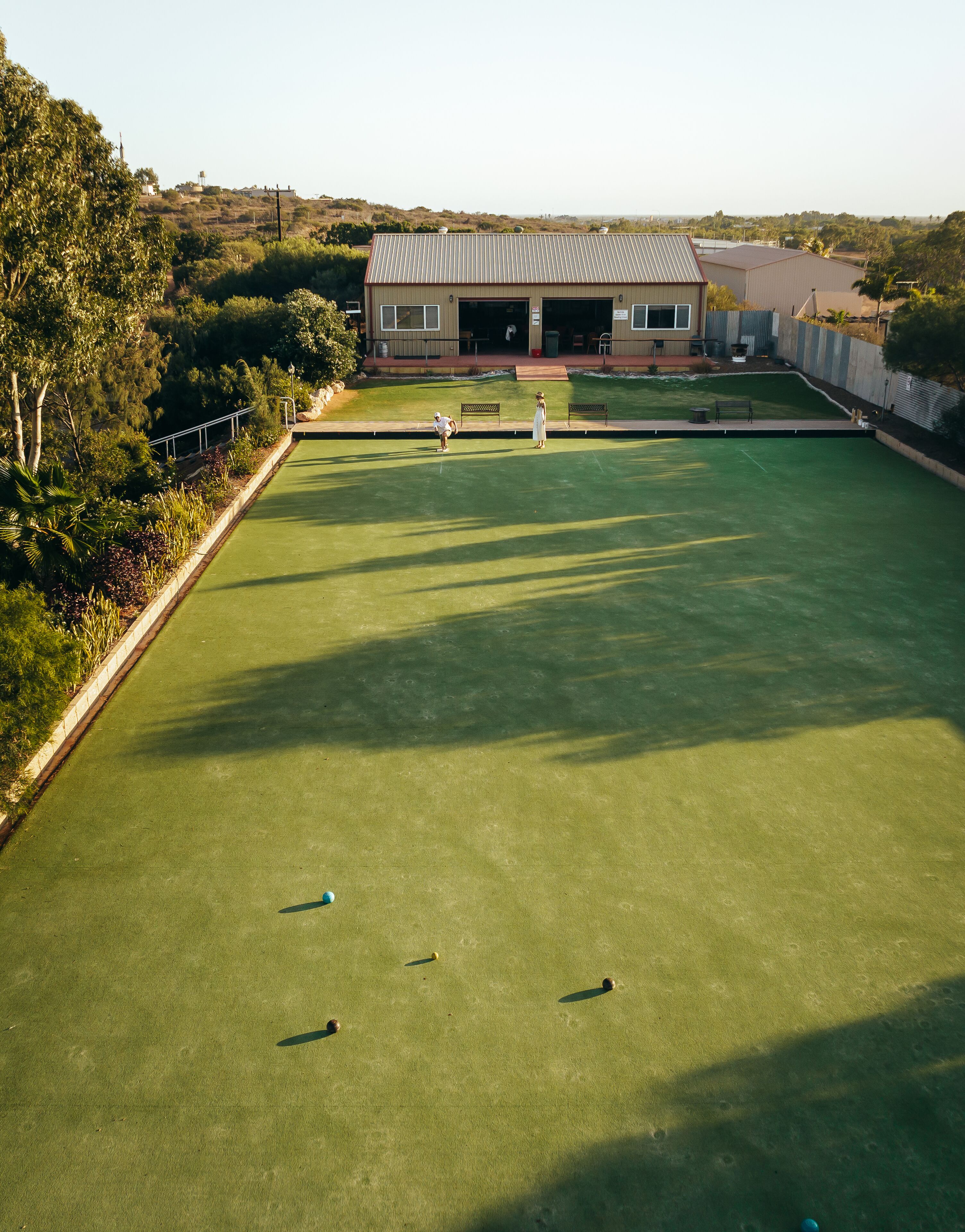 A croquet field with a building in the background.