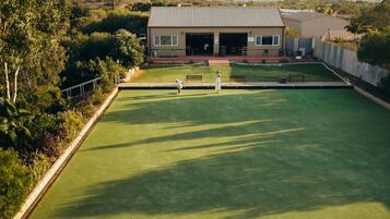 A croquet field with a building in the background.