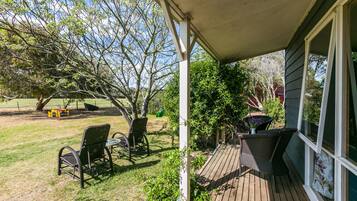 Relax in a serene outdoor space with a wooden deck, wicker chairs, and a small table.