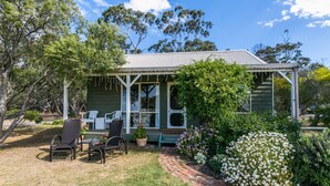 A house with a porch, outdoor seating, and a garden. - Freshwater Creek Cottages and Farm Stay (Freshwater Creek)