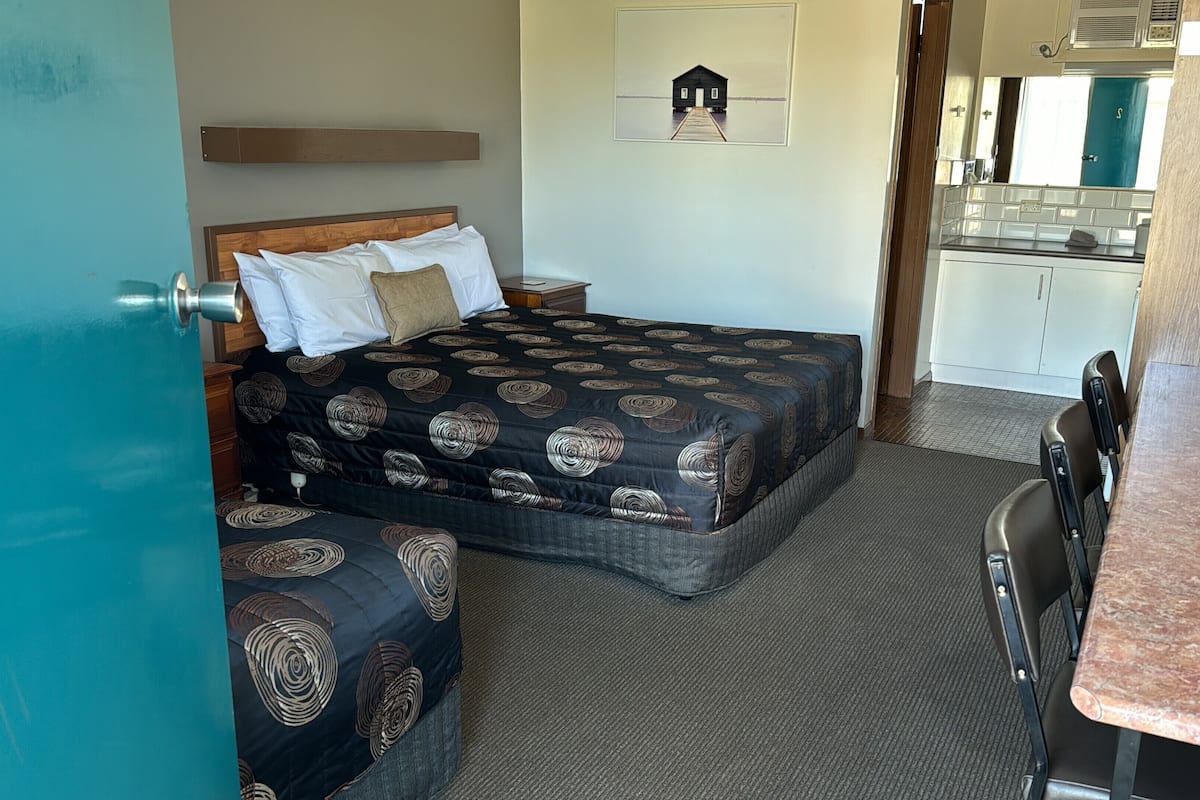 Un dormitorio con cama, escritorio y kitchenette.