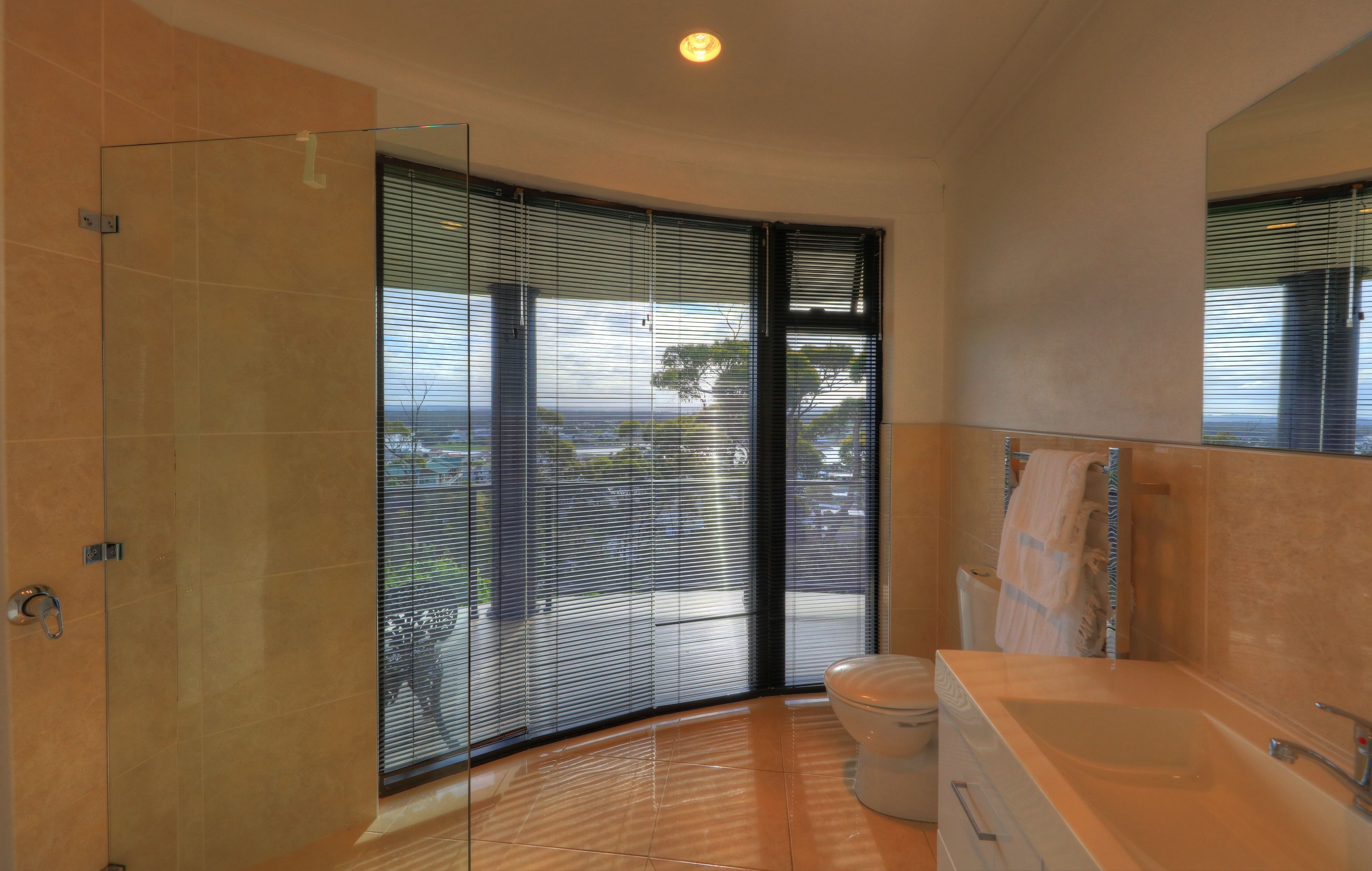 Un bagno moderno con box doccia in vetro, un water e una grande vasca da bagno.
