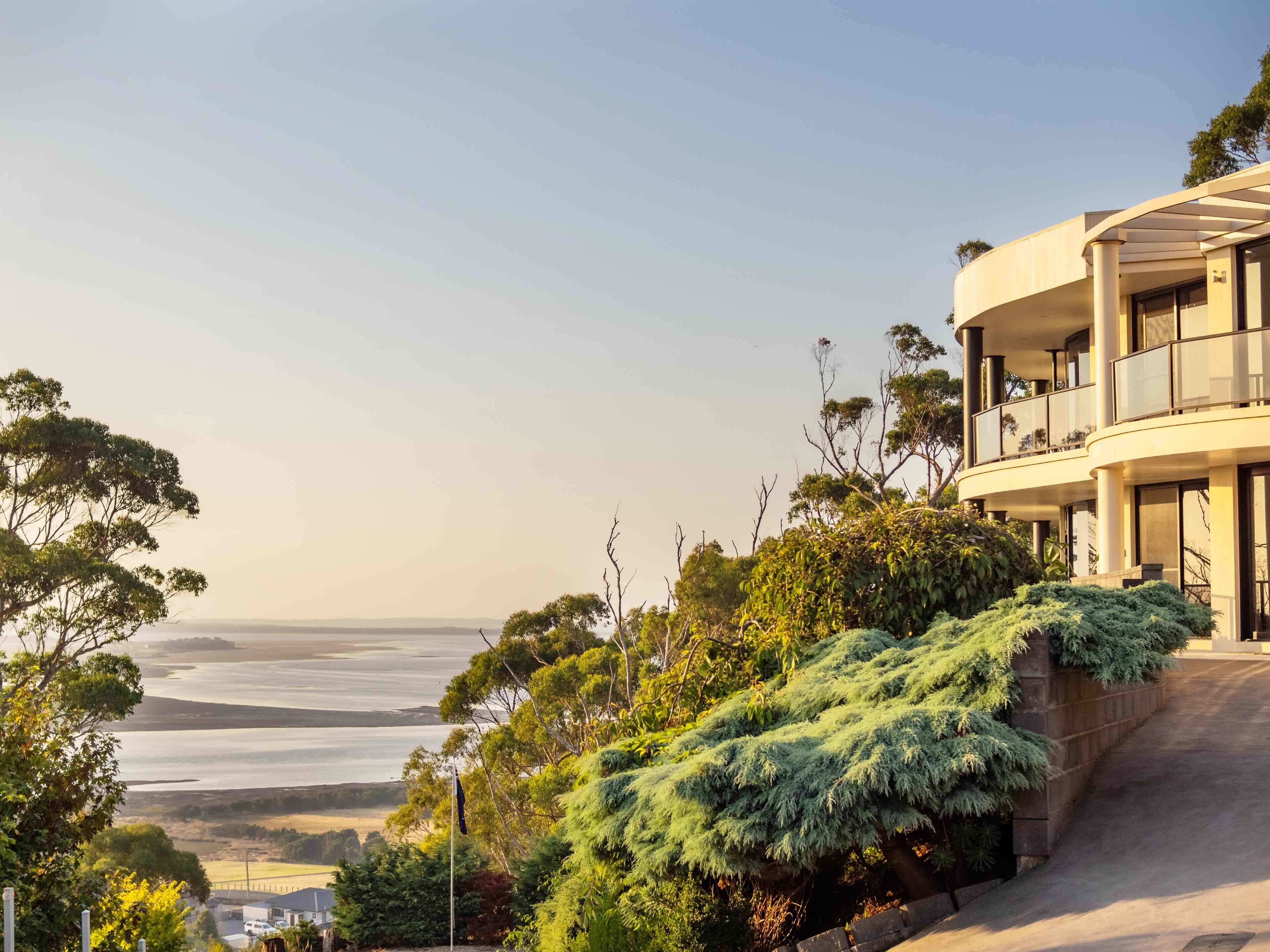 A modern building with a balcony overlooking a coastal landscape.