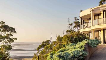 A modern building with a balcony overlooking a coastal landscape.