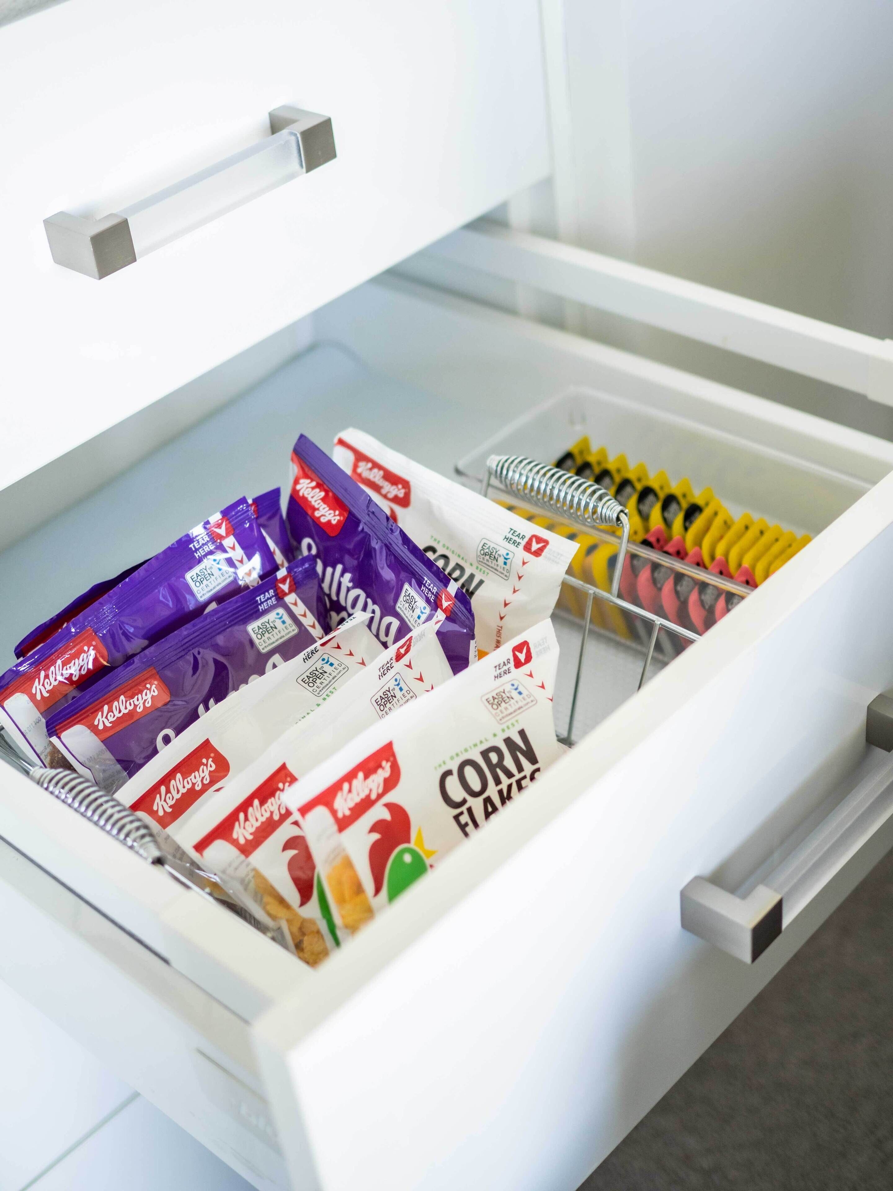 A drawer containing various food items including Kellogg's Corn Flakes and other snacks.