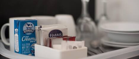 A tray with a carton of Devondale milk, a Harris milk carton, and a glass of milk.