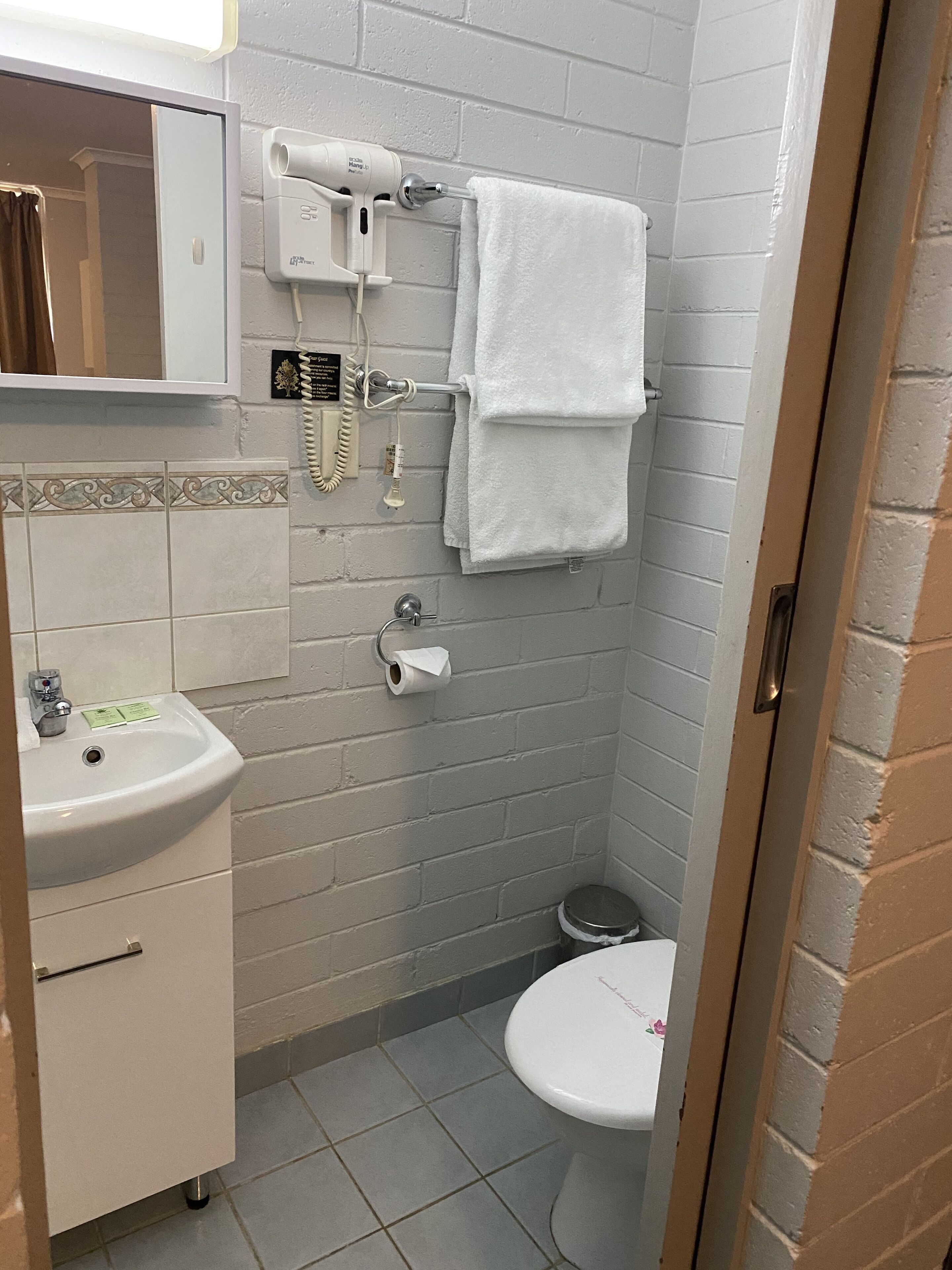 A small bathroom with a sink, toilet, and towel rack.