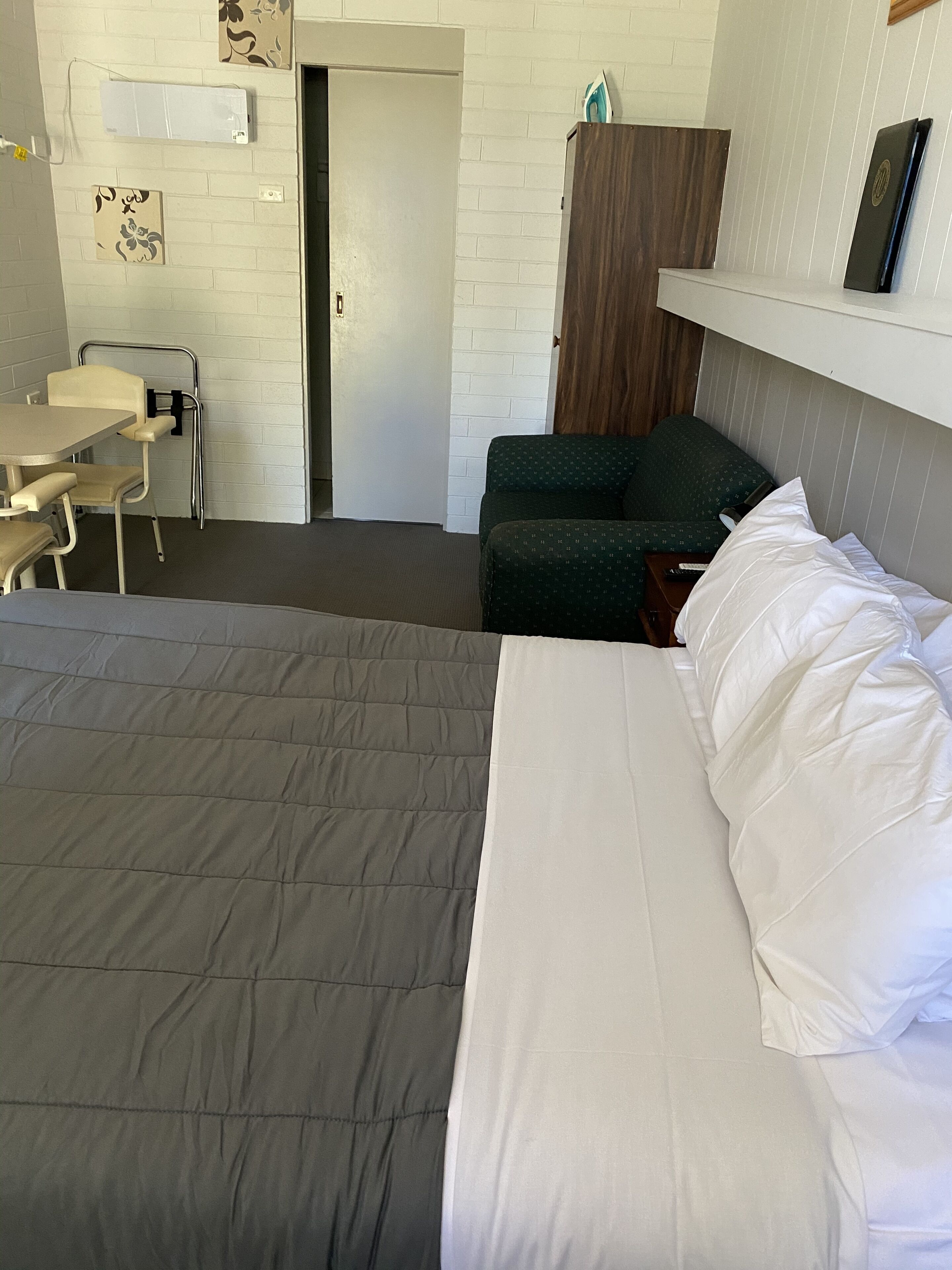 A hotel room with a bed, a desk, and a chair.