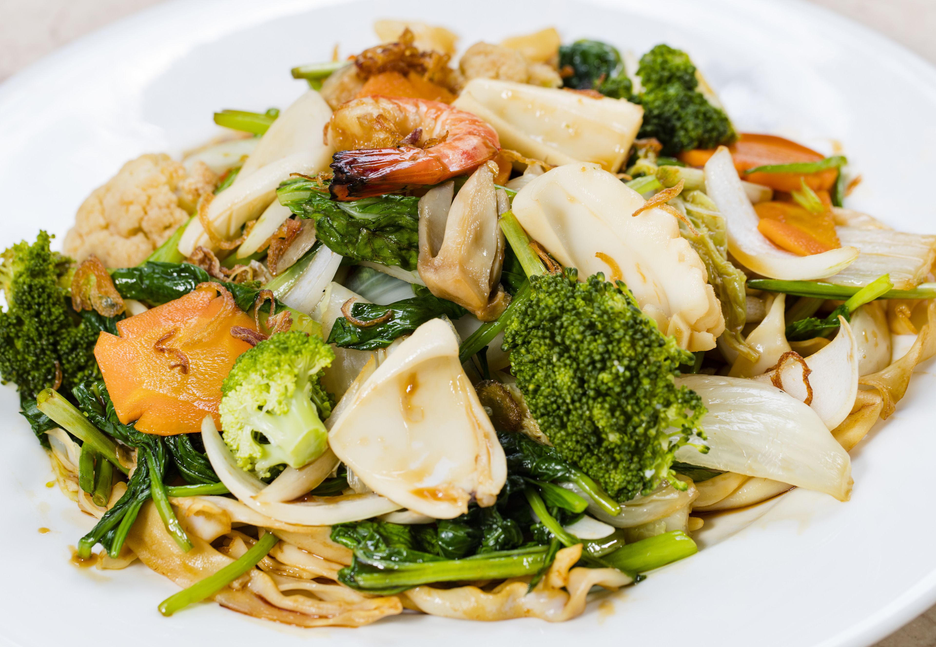 A plate of stir-fried noodles with vegetables and shrimp.
