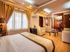 A hotel room with a large bed, a sofa, a desk, and a TV. - Vien Dong Hotel Phu My Hung (Ho Chi Minh City)