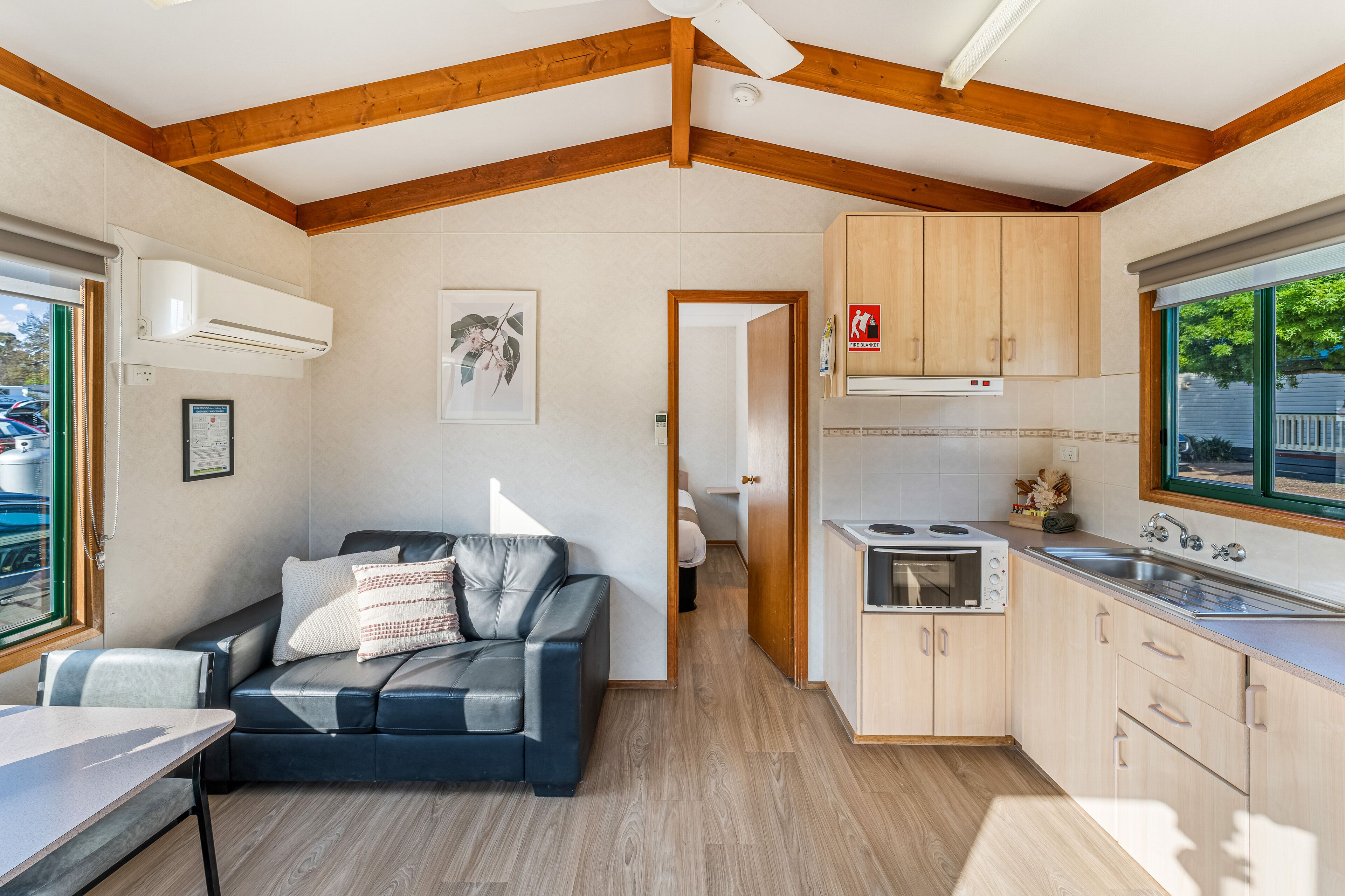 Une cuisine compacte avec des meubles en bois, une cuisinière intégrée et une fenêtre offrant une belle vue.