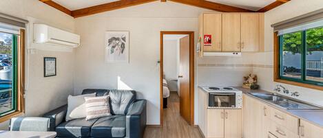 Une cuisine compacte avec des meubles en bois, une cuisinière intégrée et une fenêtre offrant une belle vue.