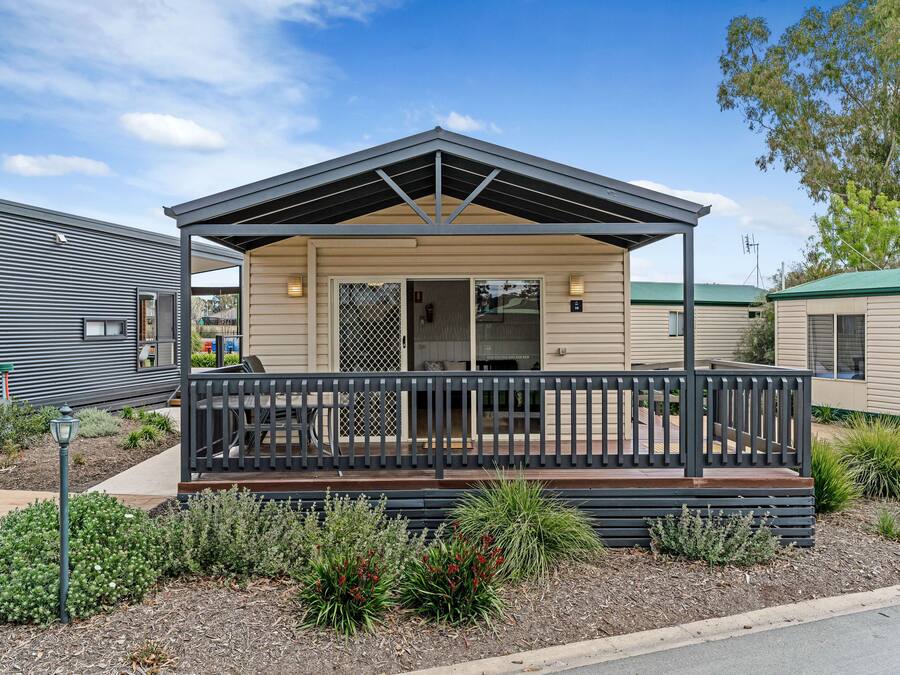 Une maison moderne de plain-pied, dotée d’un porche abrité, d’une cour clôturée et d’un jardin bien entretenu.