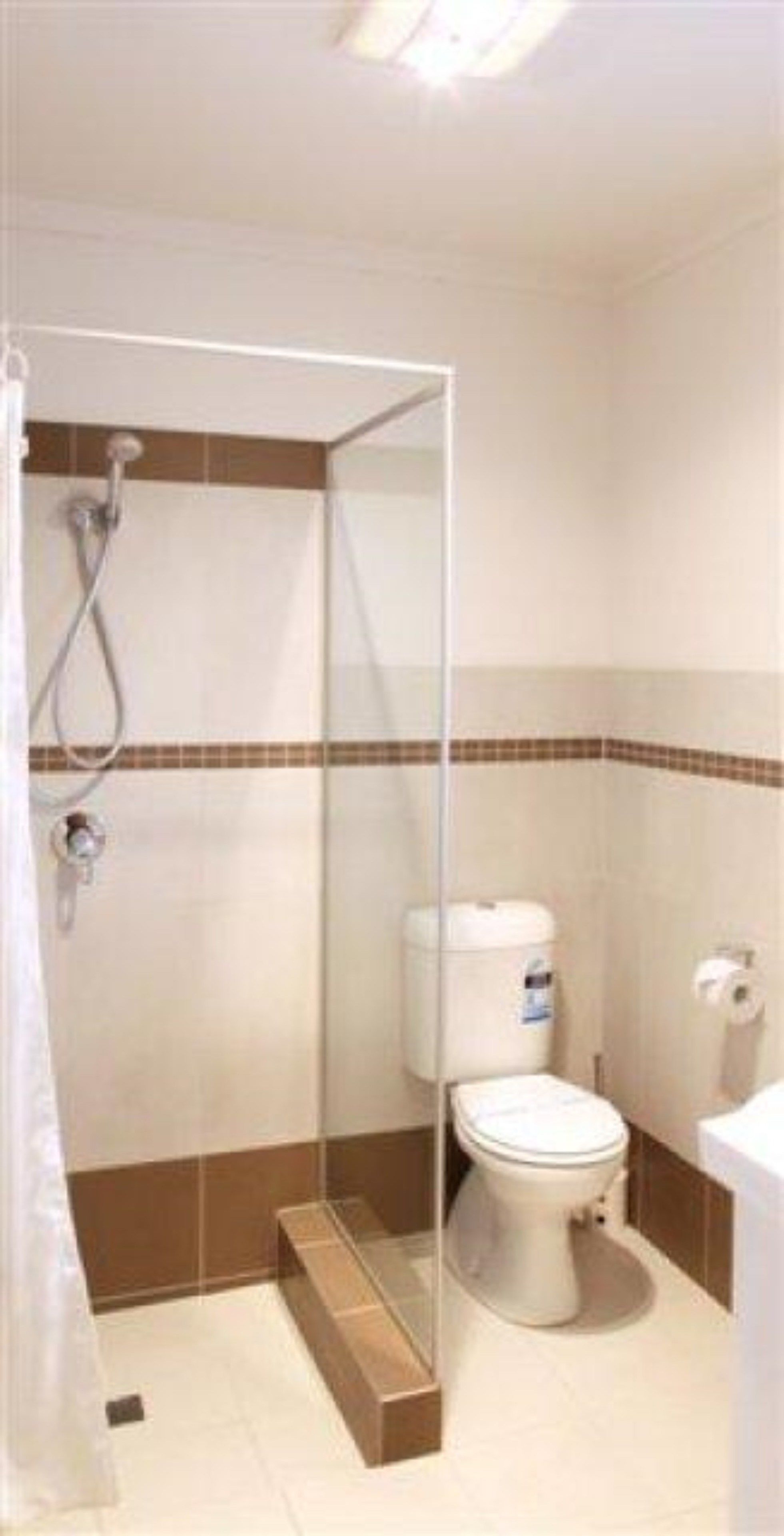 A bathroom with a shower enclosure, toilet, and sink.