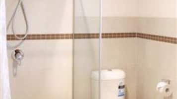 Un baño con ducha, inodoro y lavamanos.