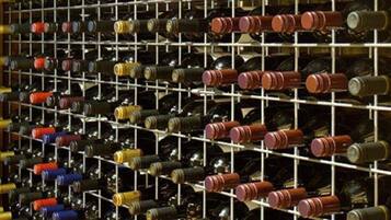 A wine cellar with rows of wine bottles on shelves.