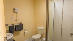 A bathroom with a toilet, sink, and towel rack.