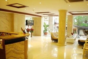 A hotel lobby with marble flooring, a reception desk, seating area, and large pillars. - Thanh Long Tan Hotel (Ho Chi Minh City)