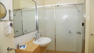 Un baño con lavamanos, espejo y ducha.