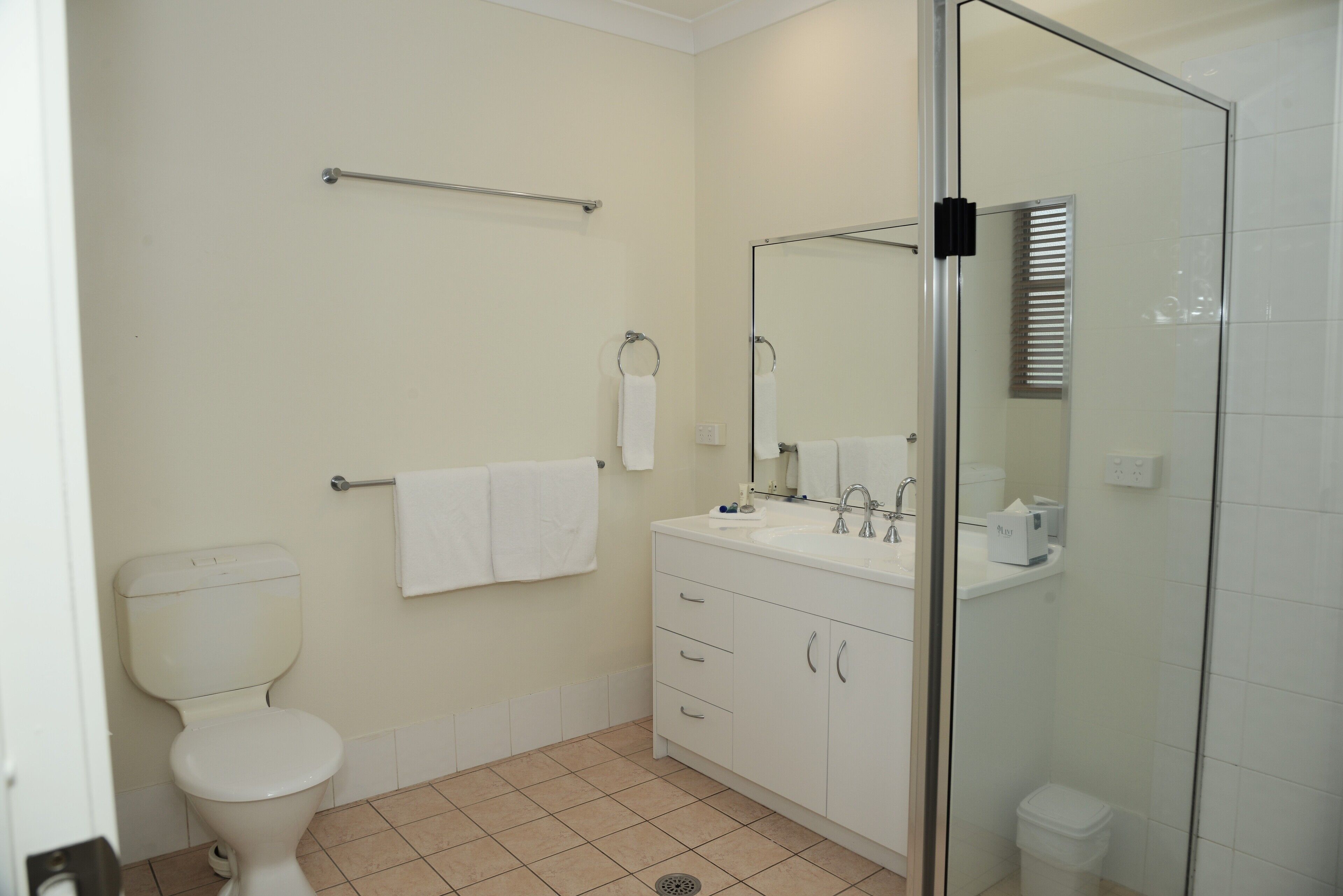 A modern bathroom with a toilet, sink, and shower area.