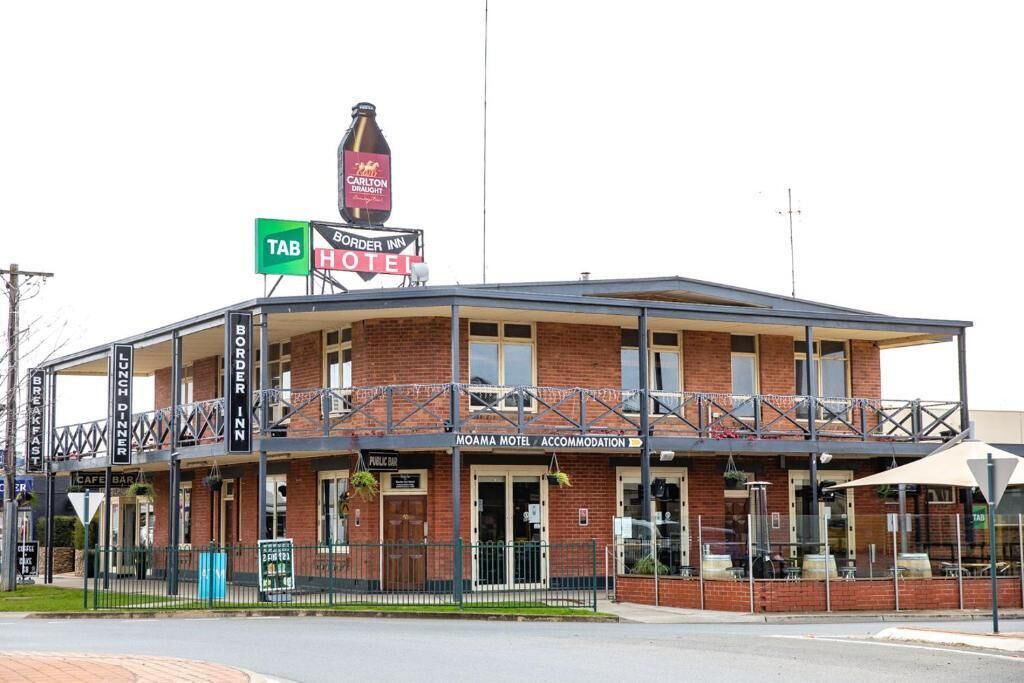 Un bâtiment à deux étages doté d’un balcon, d’une enseigne indiquant le « Carlton’s Bar » et d’une autre indiquant le « Moama Motel Accommodation ».