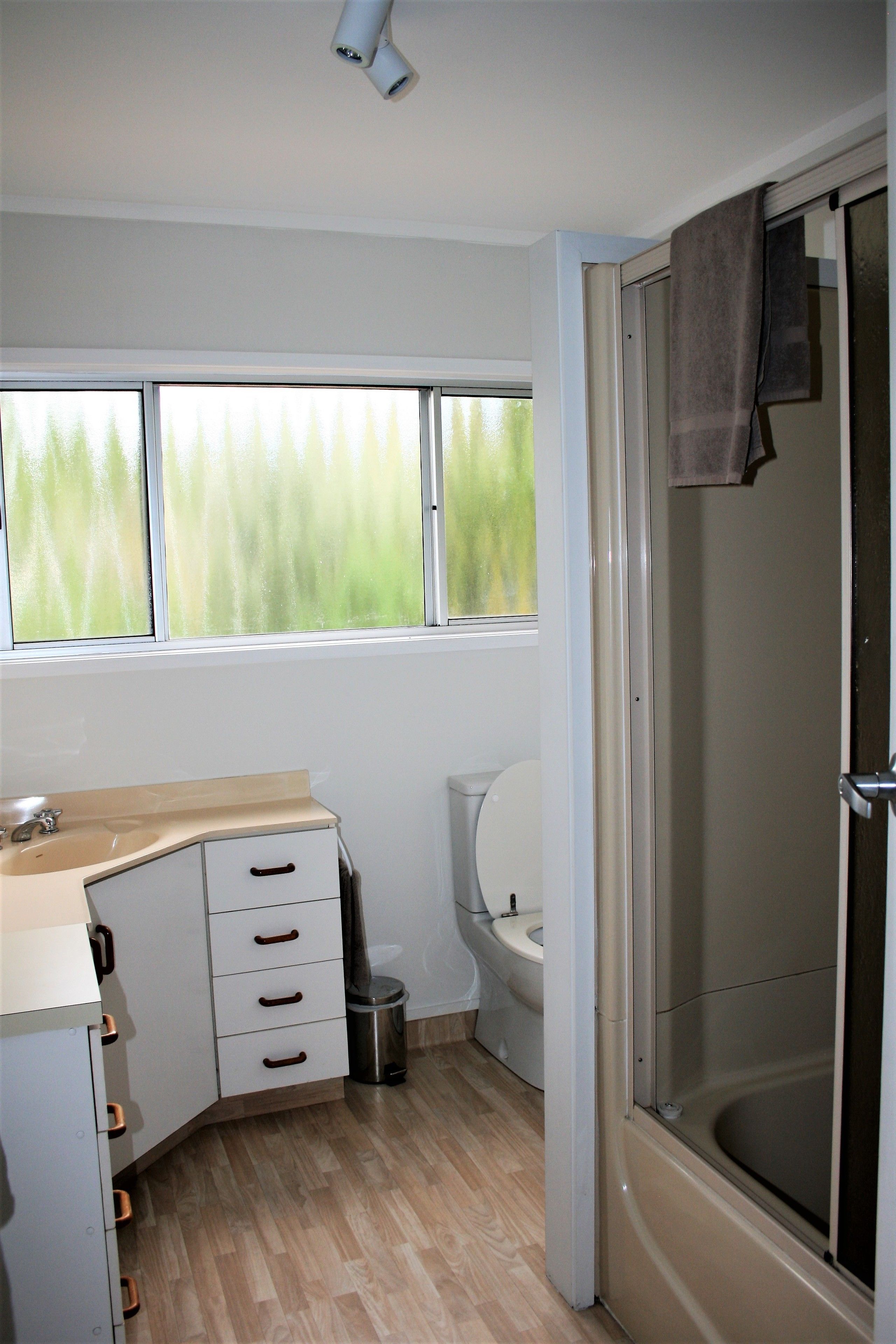 A bathroom with a toilet, sink, and shower.