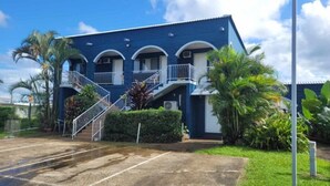 A two-story building with a blue exterior and white railings. There is a staircase leading to the upper floor. - Innisfail City Motel (Innisfail)