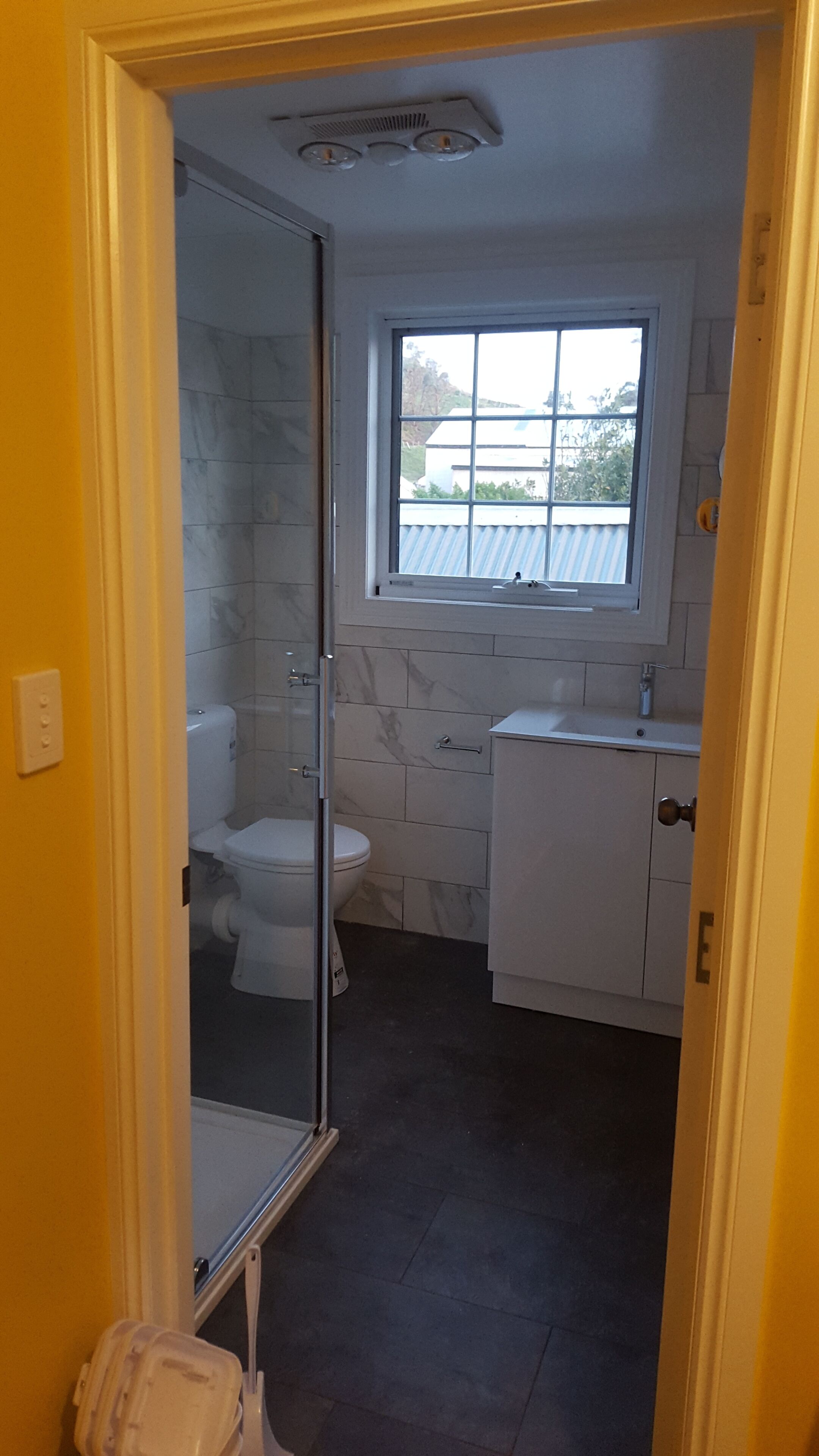Un baño pequeño con inodoro, lavamanos y ventana.