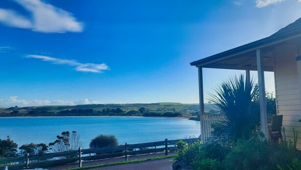 Una casa costera con vista al mar y colinas.