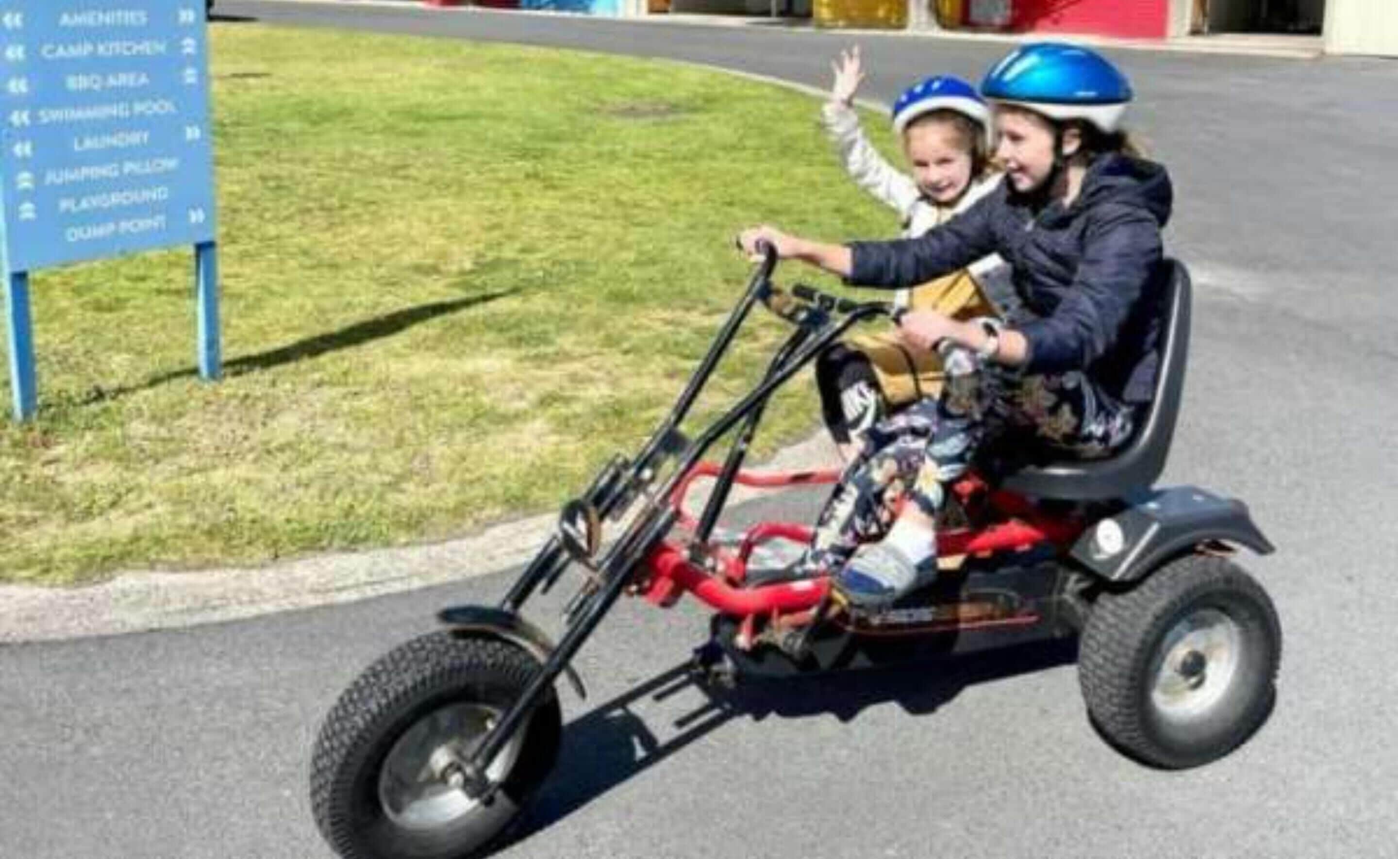Una persona che guida un triciclo con un bambino.